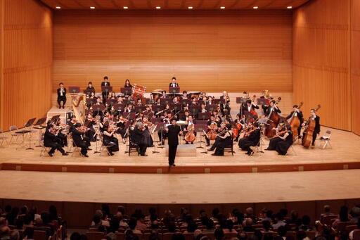 写真：コンサートホールで演奏するオーケストラ