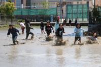 写真：田植え前の田んぼで遊ぶ児童